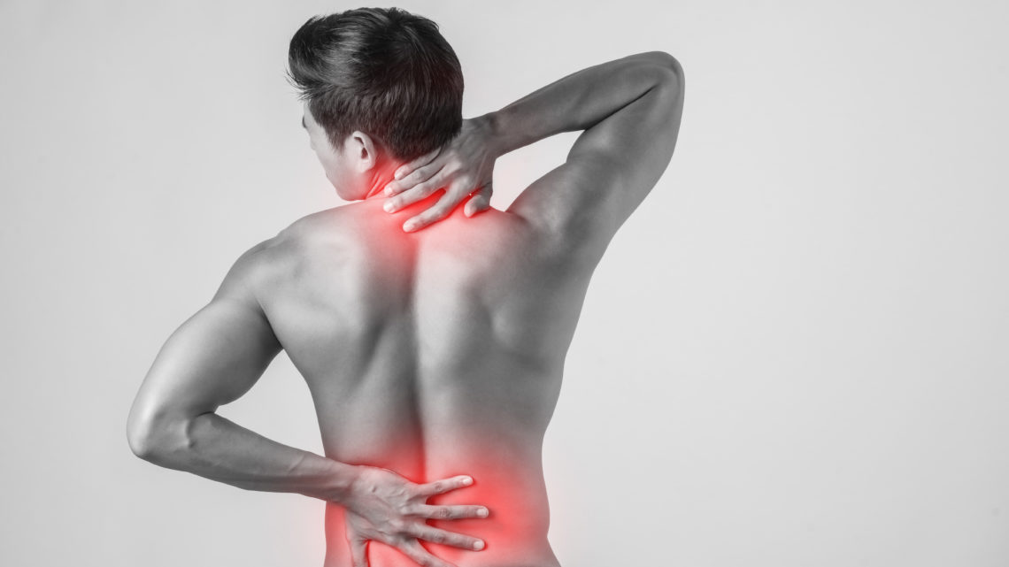 Close up of man rubbing his painful back isolated on white background.